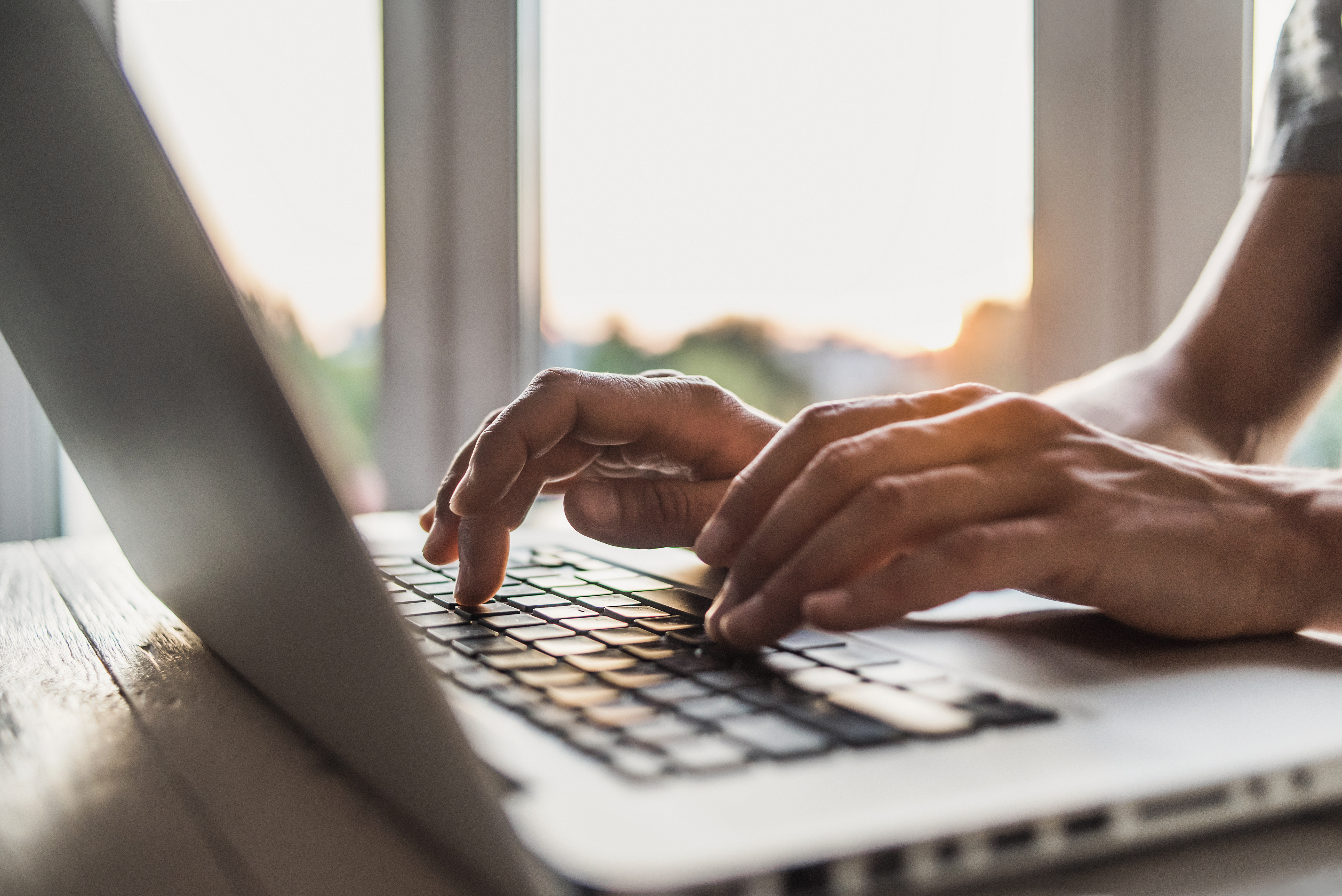 a black person hand working on a laptop 